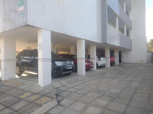 a parking lot with cars parked in front of a building at Apartamento com vista para o mar in Conde