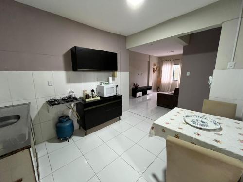 a kitchen and living room with a table and a microwave at TV Conego Leitão 2709 ap 203 in Castanhal