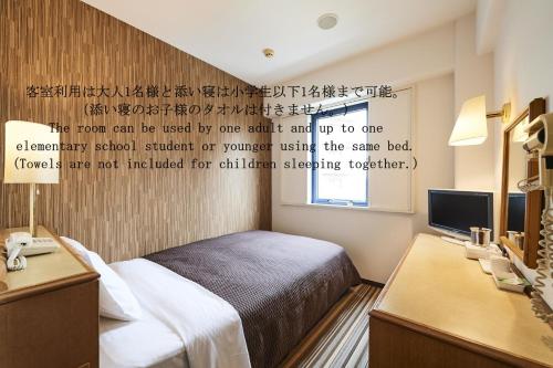 a bedroom with a bed and a writing on the wall at Urayasu Sun Hotel in Urayasu