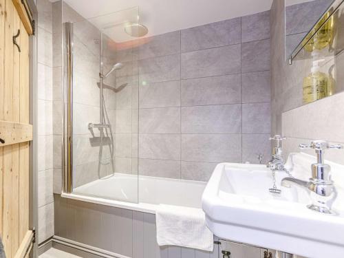 a bathroom with a sink and a shower and a tub at 3 Bed in Bourton-on-the-Water PTREE in Bourton on the Water