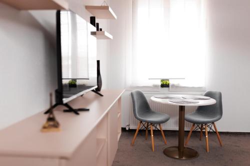 a dining room with two chairs and a table at Zenstay ApartHotel in Topliţa