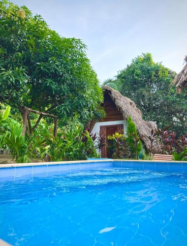 a house with a swimming pool in front of a resort at Eco Hotel Amanecer Tayrona in El Zaino