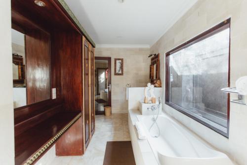 a bathroom with a tub and a large window at Kishi-Kishi ArtVilla for big company in Saba