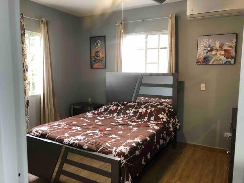 ein Schlafzimmer mit einem Bett mit einer braunen Decke in der Unterkunft Quiet Charming Apartment #4 in Sosúa