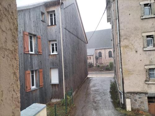eine Gasse zwischen zwei Gebäuden mit Fenstern in der Unterkunft TREFLE D'ARGENT in Gérardmer