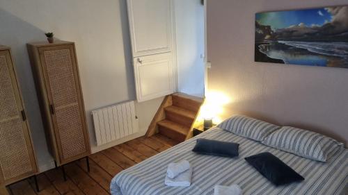 um quarto com uma cama com almofadas azuis em Le Hublot charmante maison au calme Fécamp vue sur le port em Fécamp