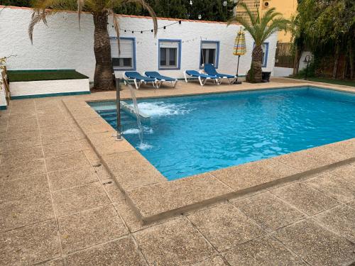 a swimming pool with blue chairs and a building at Centauro in Albir