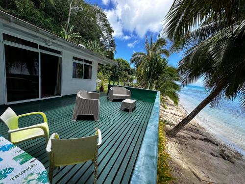 a deck with chairs and tables on the beach at Exclusive Beach & Calm at Vaiora House in Fitii