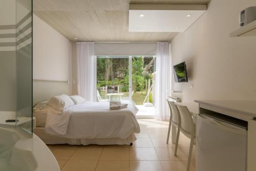 ein Schlafzimmer mit einem Bett und einem großen Fenster in der Unterkunft Villa Agostina Apart & Spa in Mar de las Pampas