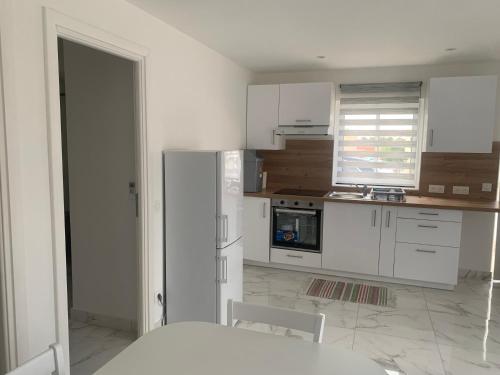  La cuisine est équipée de placards blancs et d'un réfrigérateur. dans l'établissement Résidence a CASA, à Palasca