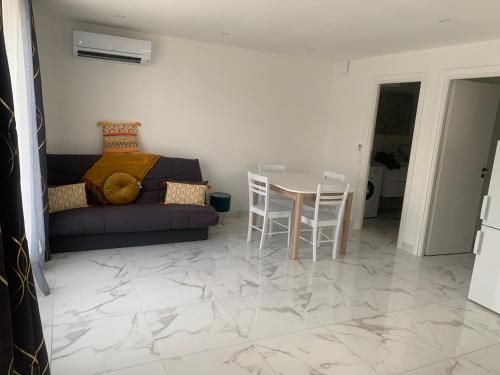 un salon avec un canapé, une table et des chaises dans l'établissement Résidence a CASA, à Palasca