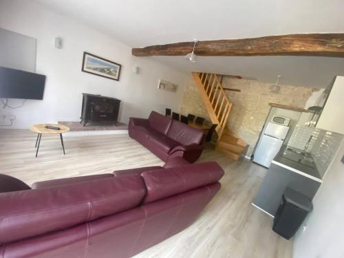 un salon avec un canapé et une cheminée dans l'établissement La Maison Saint Pierre, Aulnay, à Aulnay