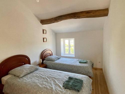 una camera da letto con due letti e una finestra di La Maison Saint Pierre, Aulnay ad Aulnay