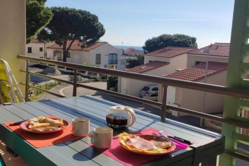 une table avec deux assiettes de nourriture sur un balcon dans l'établissement T2 2/6 p Clim vue mer piscine parking privé tout à pied, à Collioure
