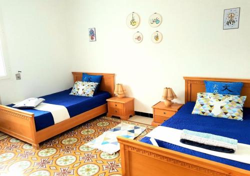 two beds in a room with blue and white at The Marsa story in La Marsa