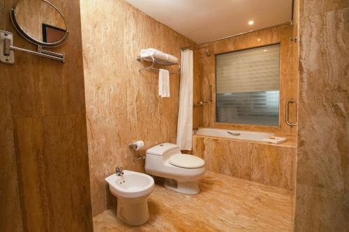 a bathroom with a toilet and a sink at Eurobuilding Hotel & Suites Guayana in Puerto Ordaz