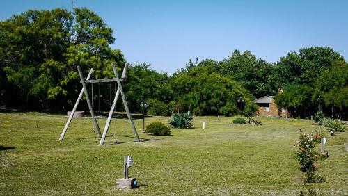 a sculpture in a field with trees and a house at cabañas Villa de las rosas in Villa de Las Rosas