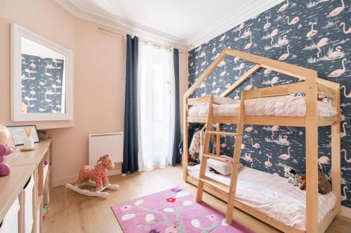 une chambre d'enfant avec un lit superposé et une fresque murale dans l'établissement Appartement Familial Parisien, à Paris