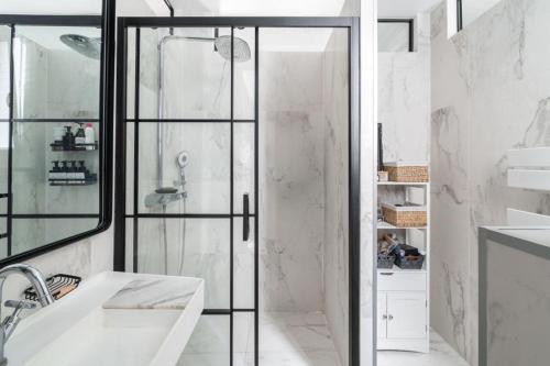 une salle de bain avec une douche avec une porte vitrée dans l'établissement Appartement Familial Parisien, à Paris