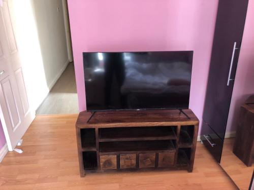 a flat screen tv sitting on top of a wooden table at Room in town centre in Saint Helens