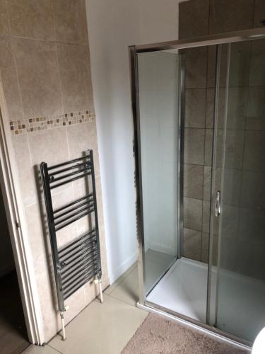 una doccia con porta in vetro in bagno di Room in town centre a Saint Helens