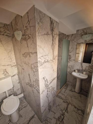a bathroom with a toilet and a sink at Villa Sunset Beach Mamaia Nord in Mamaia Sat/Năvodari