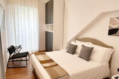 a bedroom with a white bed and a chair at Loft Metro Mergellina in Naples