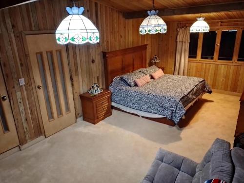 um quarto com uma cama e um sofá em Hermosa cabaña vista al bosque em La Marquesa