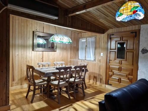 uma sala de jantar com uma mesa de madeira e cadeiras em Hermosa cabaña vista al bosque em La Marquesa