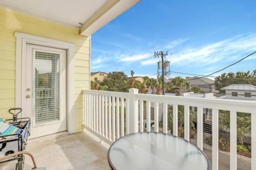 a patio with a glass table on a balcony at 2 Bed Condo Walk to the Beach in Tybee Island