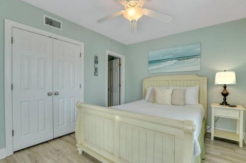 a bedroom with a white bed and a ceiling fan at 2 Bed Condo Walk to the Beach in Tybee Island