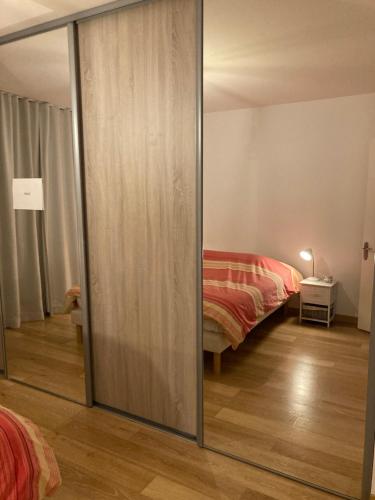 - une chambre avec 2 lits et une porte coulissante en verre dans l'établissement Appartement hyper centre avec garage, à Lille