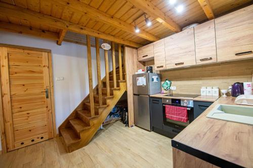 a kitchen with a staircase in a wooden house at Domek u wrót Bieszczad in Trepcza