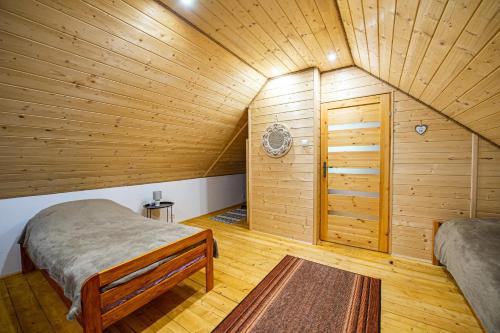 a room with two beds in a wooden room at Domek u wrót Bieszczad in Trepcza