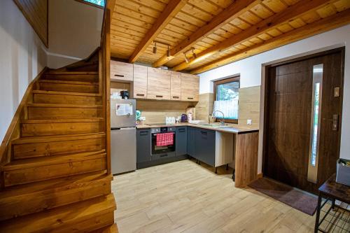a kitchen with a staircase leading into a kitchen with a refrigerator at Domek u wrót Bieszczad in Trepcza