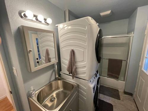 Una pequeña cocina con fregadero y refrigerador. en Cedar Oasis - Pet Friendly Cabin w Fireplace, Games and Wifi - 5 min to Big Trees, en Arnold