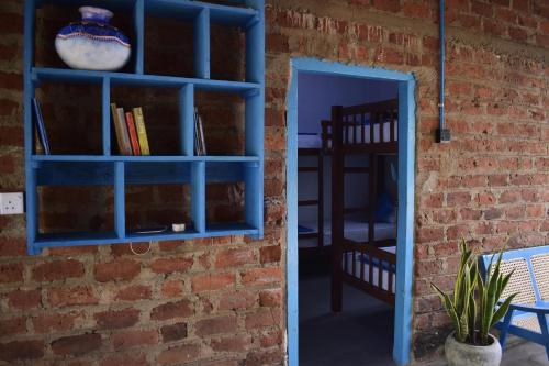 uma parede de tijolos com uma estante de livros azul ao lado de uma porta em Chill House Hostel em Anuradhapura