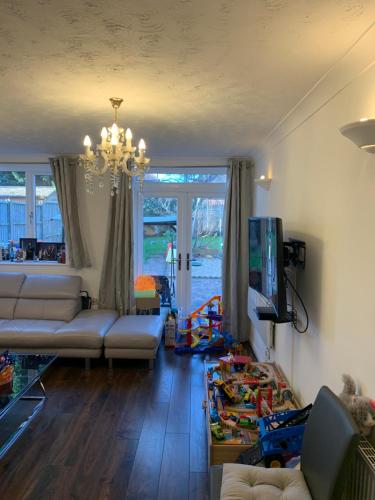 a living room with a couch and a chandelier at Adam Guest House in Leicester