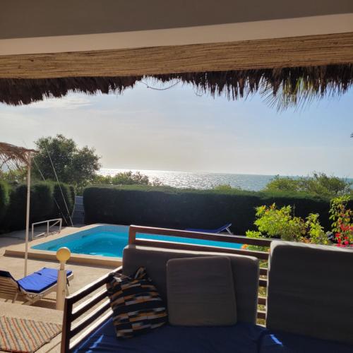 a patio with a swimming pool and a table and chairs at la villa sur la plage in Palmarin