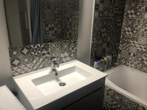a bathroom with a white sink and a bath tub at Chambre double proche Arena La Defense in Nanterre