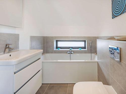a white bathroom with a sink and a tub at 3 Bed in Westward Ho 50072 in Northam