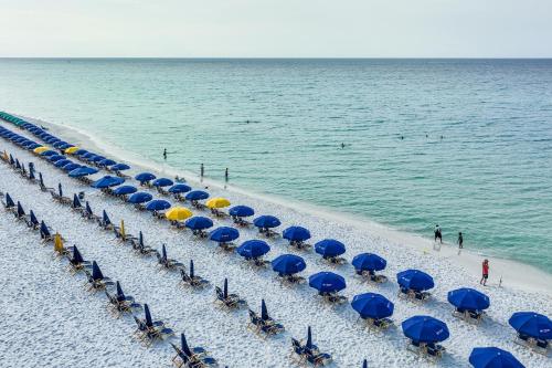 a group of blue umbrellas and chairs on a beach at Pelican Beach Resort by Panhandle Getaways in Destin