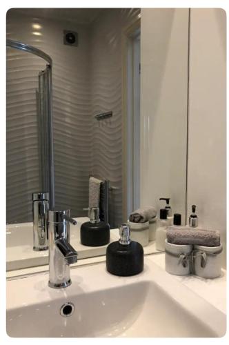 a bathroom with a sink with a large mirror at The Oaks A private room in our home With its own entrance with internal doors locked More suited to quieter guests wanting a peaceful stay in Consett