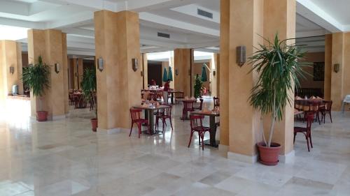 a restaurant with tables and chairs in a lobby at Caesar Bay Resort in Marsa Matruh