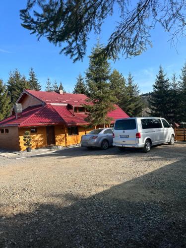 two cars parked in front of a house at Cabana Stînă - Duplex Montan in Topliţa
