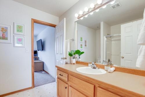 La salle de bains est pourvue d'un lavabo et d'un grand miroir. dans l'établissement Redmond Townhome on Golf Course with Private Hot Tub, à Redmond