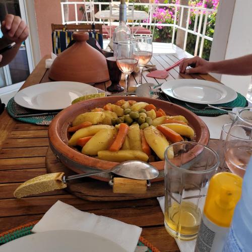 a table with a bowl of fruit and vegetables on it at la villa sur la plage in Palmarin