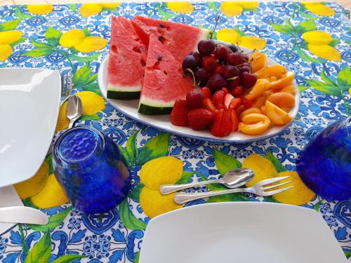 a table with a plate of fruit on a table at Caprita Guest House in Anacapri