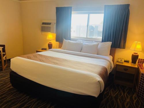 a large bed in a hotel room with a window at America's Best Value Inn Sandpoint in Sandpoint