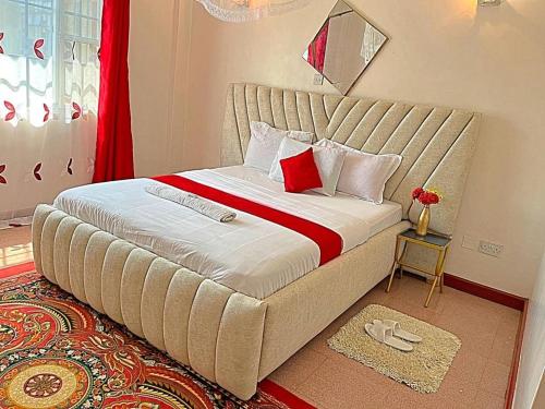 ein großes Bett mit einem großen Kopfteil in einem Schlafzimmer in der Unterkunft Homely apt 3 (three) in Kisumu